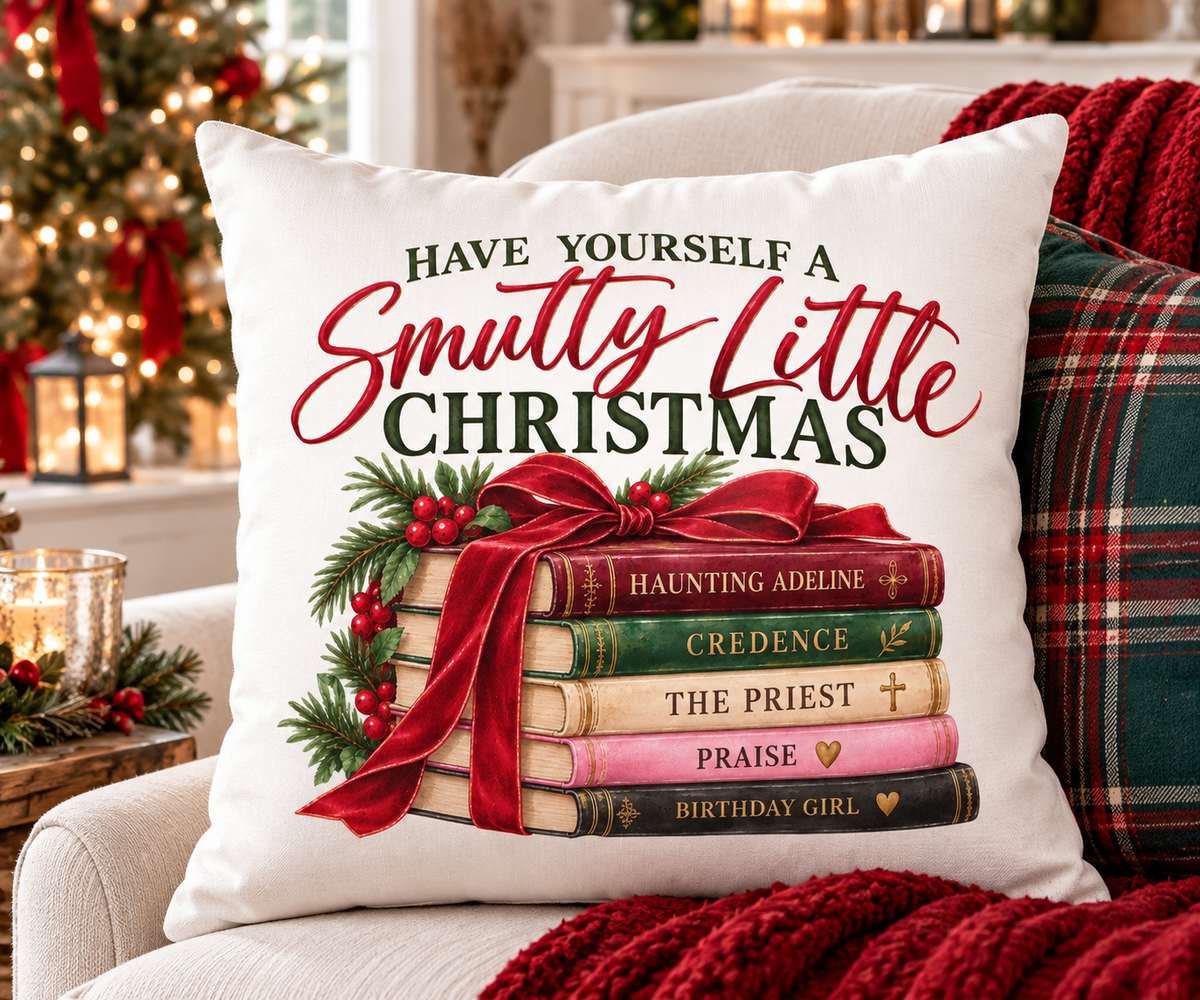 White Christmas pillow cover featuring “Have Yourself a Smutty Little Christmas” in red and green with five romance books tied in a red bow, evergreen and berries.